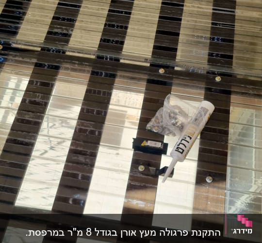 חומרי איטום וברגים על משטח עץ